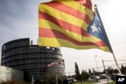 A demonstrator waves a Catalan flag in support of the disputed independence vote Sunday in Catalonia during a protest in front of the European Parliament in Strasbourg, France, Oct. 4, 2017.