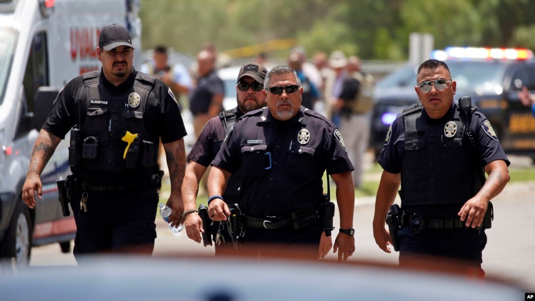 FILE - Police walk near Robb Elementary School following shootings on May 24, 2022, in Uvalde, Texas. A federal report released on Jan. 18, 2024, into the halting law enforcement response to the shootings revived scrutiny of the hundreds of officers who responded to the massacre.