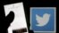 FILE - A man reads tweets on his phone in front of a displayed Twitter logo in Bordeaux, southwestern France.