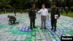 El presidente de Colombia, Juan Manuel Santos observa la 12 toneladas de cocaína incautada en Apartado, Colombia, el miércoles, 8 de noviembre de 2017.