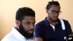 FILE - Rashon Nelson listens to a reporter's question alongside Donte Robinson during an interview with the Associated Press in Philadelphia, April 18, 2018. 