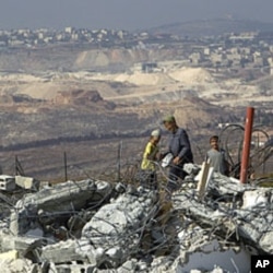 Jewish settler boys stand atop ruins of razed buildings in the unauthorized Jewish hilltop outpost of Migron, near the West Bank city of Ramallah, September 5, 2011.