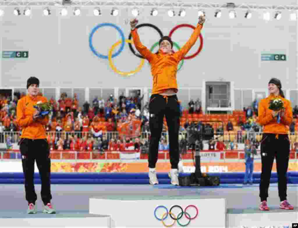 Gold medallist Jorien ter Mors of the Netherlands, center, jumps in celebration, applauded by country athletes, silver medallist Ireen Wust, left, and bronze medallist Lotte van Beek during the flower ceremony for the women's 1,500-meter speedskating race