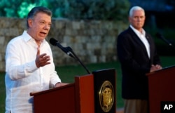 FILE - Colombia's President Juan Manuel Santos, left, talks to the media as U.S. Vice President Mike Pence listens during a joint press conference at the presidential guesthouse in Cartagena, Colombia, Aug. 13, 2017.