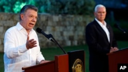 Colombia's President Juan Manuel Santos, left, talks to the media as U.S. Vice President Mike Pence listens during a joint press conference at the presidential guesthouse in Cartagena, Colombia, Aug. 13, 2017.