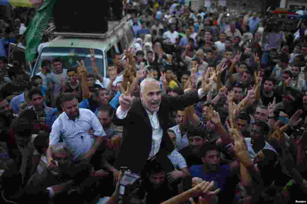 Hamas spokesman Fawzi Barhoum is carried by Palestinians as they celebrate a ceasefire in Gaza City, Aug. 26, 2014.