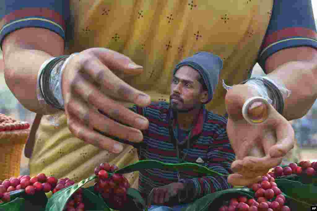 A worker paints the hand of a huge clay model of a tribal woman on the Indian state of Karnataka&#39;s tableau for the upcoming Republic Day parade, in New Delhi.