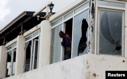 FILE PHOTO: A Somali police officer looks from the broken windows following an attack by Al Shabaab militants at the Liido beach in Mogadishu.Somalia June 10, 2023.