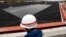 FILE - A worker stands in front of a newly installed fresh water reservoir, used to cool down nuclear reactors in case of emergencies, at Tokyo Electric Power Co.'s (TEPCO) Kashiwazaki Kariwa nuclear power plant, which is the world's biggest, in Kashiwazaki, Nov
