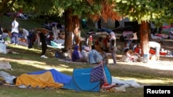 Migrants are seen in a makeshift camp at a park near the San Giovanni railway station in Como, Italy, Aug. 12, 2016. 