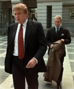 FILE - Donald Trump walks to the federal courthouse in Newark, N.J., with Roger Stone, who was then director of Trump's presidential exploratory committee, Oct. 25, 1999, for the swearing-in of Trump's sister as a federal judge.