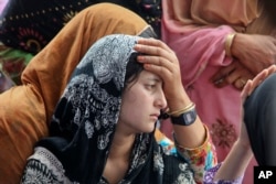 Daughter of Indian civilian Sarpanch Karamat Hussain who was killed in Pakistani shelling mourns at Balakot sector in Poonch, Jammu and Kashmir, India, Aug.16, 2015.