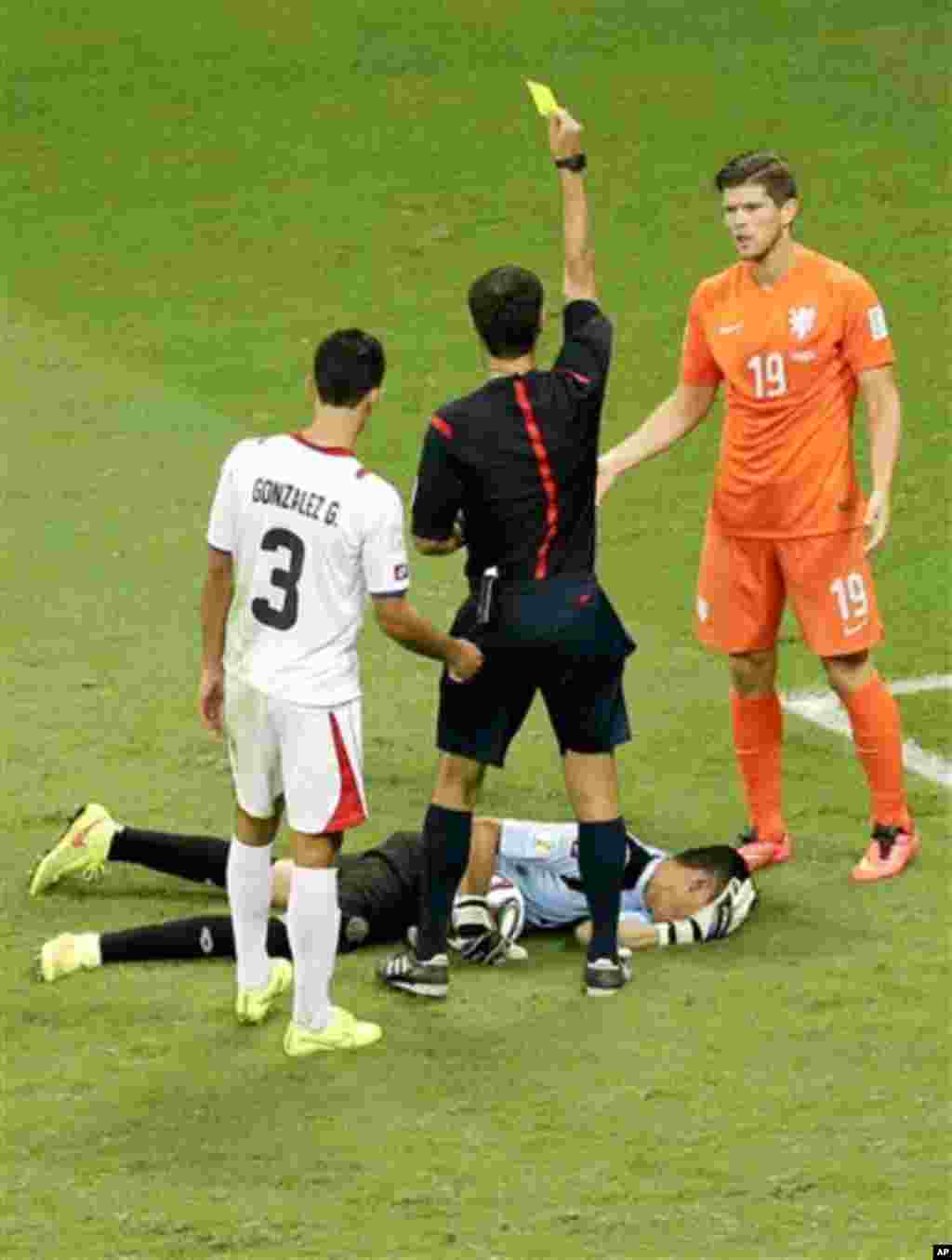 Netherlands' Klaas-Jan Huntelaar gets a yellow card for fouling Costa Rica's goalkeeper Keylor Navas during the World Cup quarterfinal soccer match between the Netherlands and Costa Rica at the Arena Fonte Nova in Salvador, Brazil, Saturday, July 5, 2014.