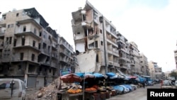 FILE - Stalls are seen on a street beside damaged buildings in the rebel held al-Shaar neighborhood of Aleppo, Syria, Feb. 10, 2016. 