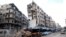 FILE - Stalls are seen on a street beside damaged buildings in the rebel held al-Shaar neighborhood of Aleppo, Syria, Feb. 10, 2016. 