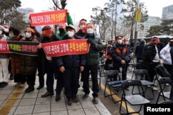 Aksi unjuk rasa para pemilik bisnis Korea Selatan di dekat Majelis Nasional di Seoul, Korea Selatan, 25 Januari 2022, memprotes aturan jarak sosial baru pemerintah yang mulai berlaku awal bulan ini. (REUTERS/Kim Hong-Ji)
