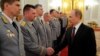 Russian President Vladimir Putin shakes hands at the presentation ceremony of the top military brass in the Kremlin, March 28, 2014.