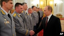 Russian President Vladimir Putin, right, shakes hands with his generals in Moscow, Russia, Friday, March 28, 2014. The generals are the "top brasses" but Putin is the "big cheese" in Russia.