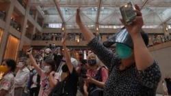 Hong Kong China UProtesters gesture with five fingers, signifying the "Five demands - not one less" in a shopping mall during a protest against China's national security legislation for the city, in Hong Kong, Monday, June 1, 2020. (AP Photo/Vincent Yu)