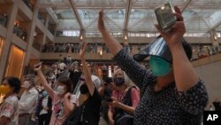Hong Kong China UProtesters gesture with five fingers, signifying the "Five demands - not one less" in a shopping mall during a protest against China's national security legislation for the city, in Hong Kong, Monday, June 1, 2020. (AP Photo/Vincent Yu)