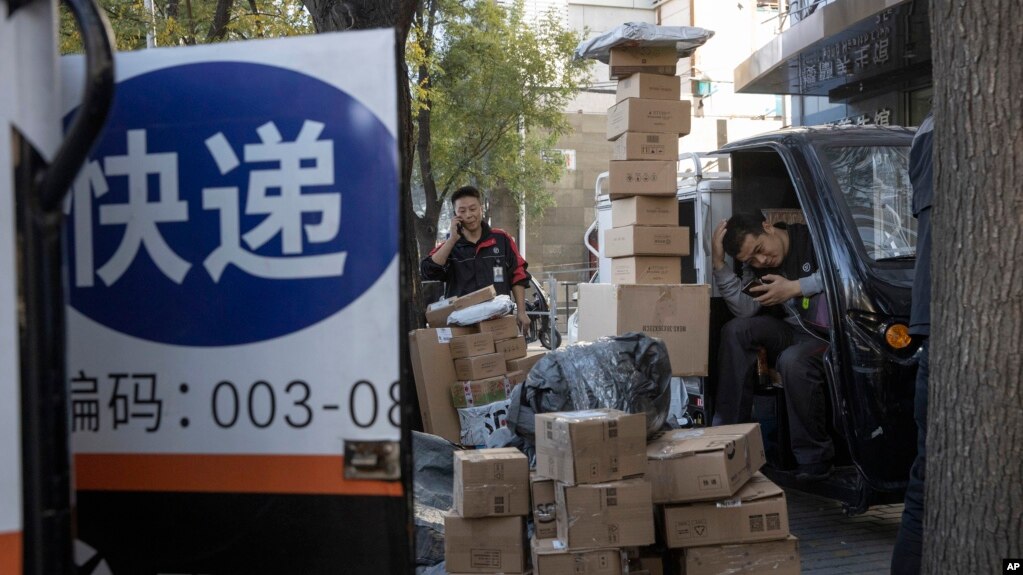 中国“光棍节”当天，北京街头快递小哥在分发运送包裹（2019年11月11日）(photo:VOA)