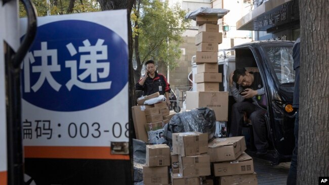 中国“光棍节”当天,北京街头快递小哥在分发运送包裹(2019年11月11日)