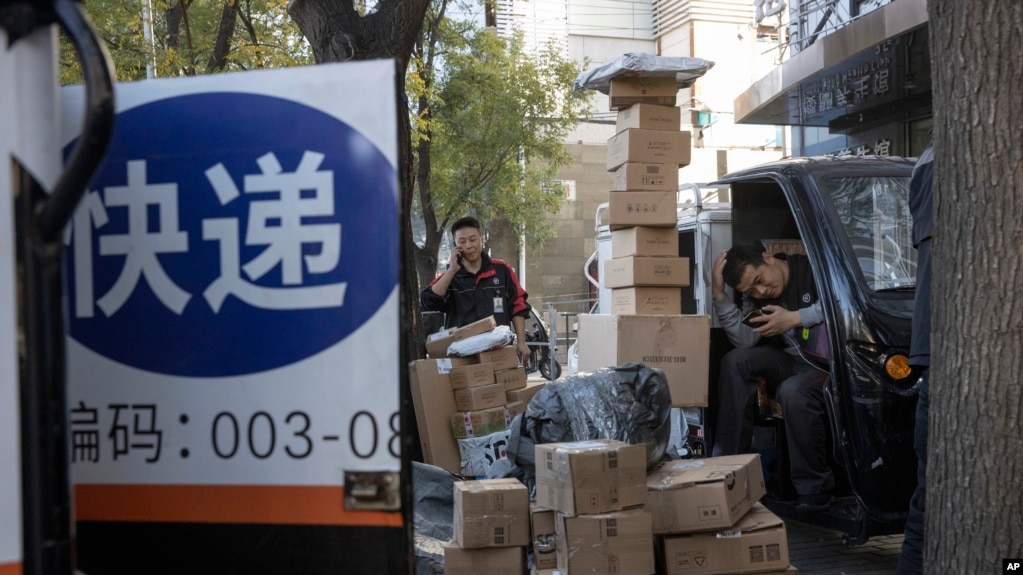 资料照片：中国“光棍节”当天，北京街头快递小哥在分发运送包裹（2019年11月11日）(photo:VOA)