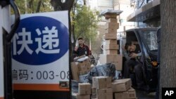 中國“光棍節”當天，北京街頭快遞工人在分發運送包裹（2019年11月11日）
