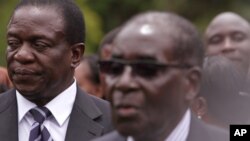 Emmerson Mnangagwa, left, Vice President of Zimbabwe stands next to Zimbabwean President Robert Mugabe after the swearing in ceremony at State House in Harare, Friday, Dec, 12, 2014. (AP Photo/Tsvangirayi Mukwazhi)