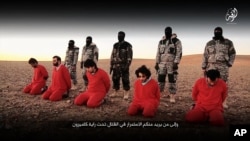 This undated image, taken from video posted online Jan. 3, 2016, by the communications arm of the Islamic State group, purports to show IS militants executing five men who they accuse of having spied for Britain in Syria.