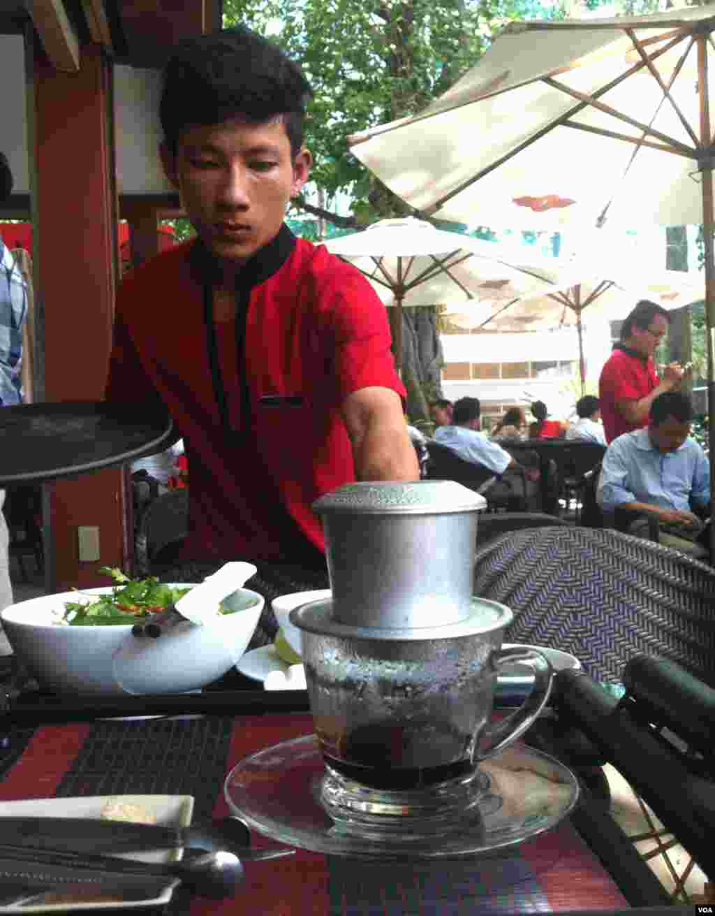Pelayan kedai kopi menyajikan kopi gaya Vietnam di Ho Chi Minh City. (D. Schearf/VOA)