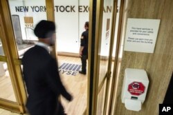 A hand sanitizer dispenser is installed at the entrance to the New York Stock Exchange trading floor, March 3, 2020.