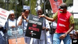FILE - Demonstrators wear mock prison outfits to show that they want to imprison those engaged in corruption, in Nairobi, Kenya Thursday, Nov. 3, 2016.