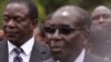 Emmerson Mnangagwa, left, Vice President of Zimbabwe stands next to Zimbabwean President Robert Mugabe after the swearing in ceremony at State House in Harare, Friday, Dec, 12, 2014. (AP Photo/Tsvangirayi Mukwazhi)