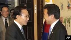 South Korean President Lee Myung-bak, left, shakes hands with Sohn Hak-kyu, chairman of the leading opposition Democratic Party, before their meeting at the National Assembly in Seoul, Noyember15, 2011.