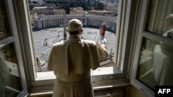 El papa Francisco da la bendición a una vacía Plaza de San Pedro, en un gesto simbólico, luego de pronunciar su sermón dominical del Angelus, el 15 de marzo. Foto de servicio de prensa del Vaticano.