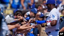 Los Angeles Dodgers' Yasiel Puig signs autographs for fans prior to an opening day baseball game against the San Diego Padres, Monday, April 6, 2015, in Los Angeles. (AP Photo/Mark J. Terrill)