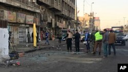 15일 이라크 바그다드 경찰이 자살폭탄 공격 현장을 조사하고 있다.