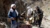 FILE - Taliban fighters stand with their weapons in Shindand district of Herat province, Afghanistan, May 27, 2016.