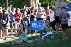 FILE - Local residents snap pictures and look on as Democratic U.S. presidential nominee and former Vice President Joe Biden participates visits amid the coronavirus pandemic during a campaign stop in in Wauwatosa, Wisconsin, Sept. 3, 2020.