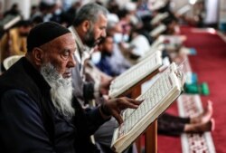 Seorang pria lansia Palestina membaca Alquran di sebuah masjid di kamp pengungsi Nuseirat di Jalur Gaza tengah, di bulan suci Ramadan, 18 April 2021. (Foto: MAHMUD HAMS / AFP)