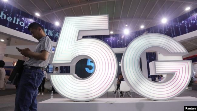 A man stands next to a sign of 5G at the Tencent Global Digital Ecosystem Summit in Kunming, Yunnan province, China, May 23, 2019.