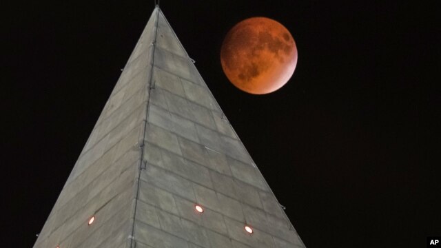 La llamada Luna sangrienta pasa detrás del pico del obelisco dedicado a George Washington, en la capital estadounidense.