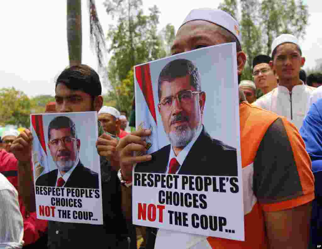 Protesters hold posters of Egypt's ousted President Mohamed Morsi during a rally after Friday prayer at a mosque in Shah Alam, outside Kuala Lumpur, Malaysia, Aug. 16, 2013.
