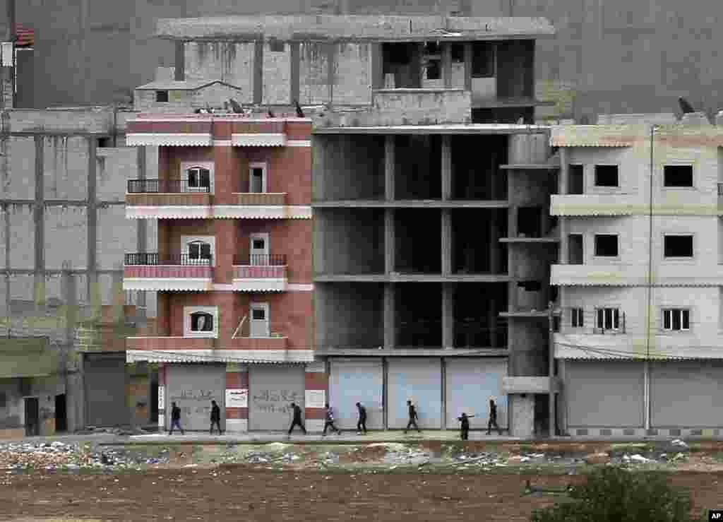 Kurdish fighters walk to their positions in Kobani, Syria, Oct. 19, 2014.