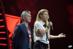 Argentinian President Mauricio Macri shares the stage with singer Shakira as she speaks to the crowd during the Global Citizen Festival concert on the eve of the G-20 summit in Hamburg, northern Germany, July 6, 2017.