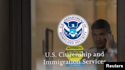 FILE - A security guard looks out of the U.S. Citizenship and Immigration Services offices in New York, Aug. 15, 2012.