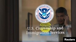 FILE - A security guard looks out of the U.S. Citizenship and Immigration Services offices in New York, Aug. 15, 2012.