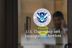 FILE - A security guard looks out of the U.S. Citizenship and Immigration Services offices in New York, Aug. 15, 2012.