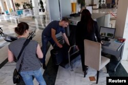 Russian tourists get their luggage back from a scanner after security check at the Steigenberger Kantaoui Bay resort, in Sousse, Tunisia, Sept. 29, 2017.